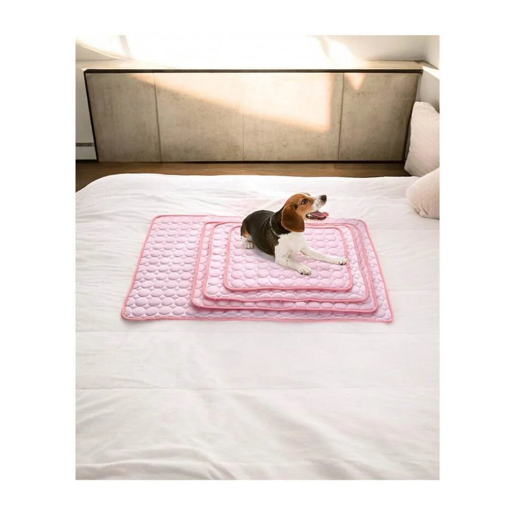 Hund liegt auf rosa Kühlmatte zur Abkühlung.