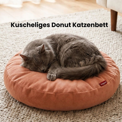 Katze schläft gemütlich auf weichem rundem Katzenbett.
