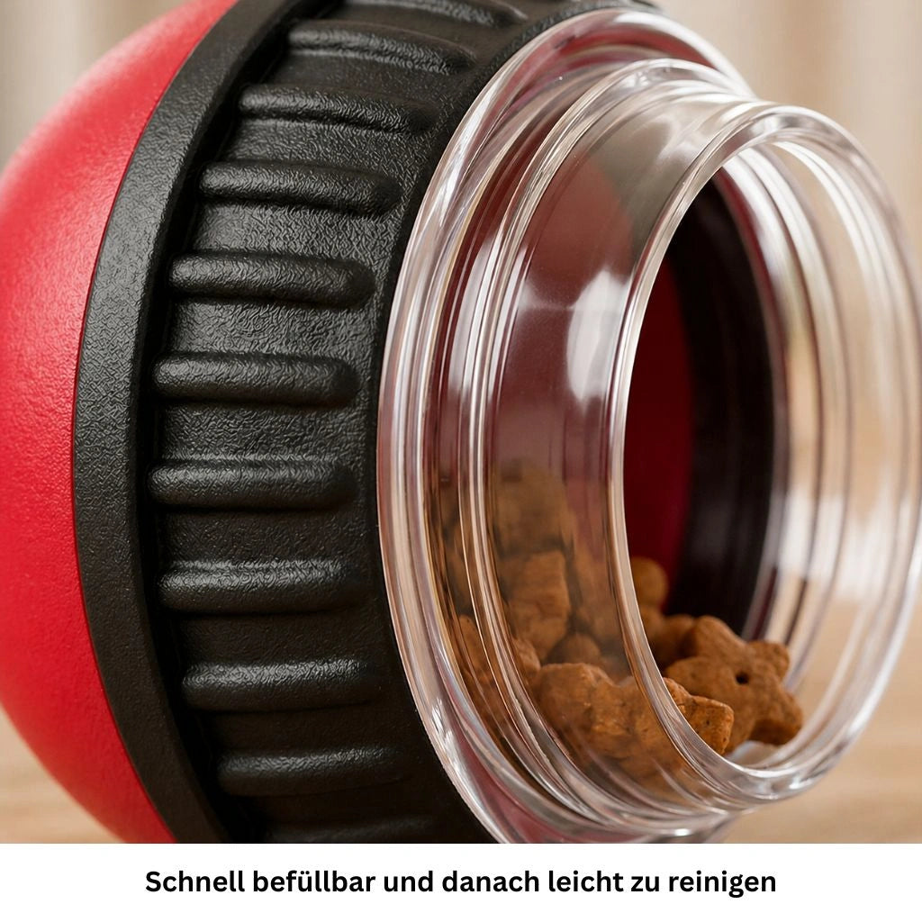 Nahaufnahme des roten Hundespielzeugs mit transparenter Öffnung und sichtbaren Leckerlis im Inneren.