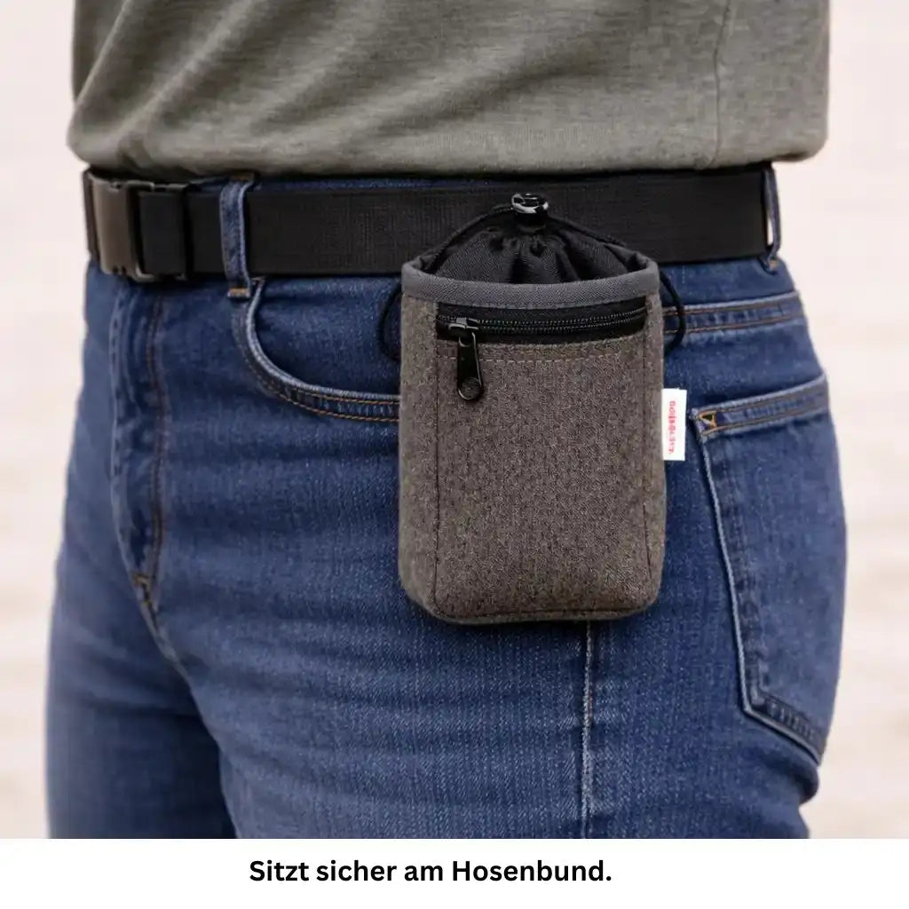 Kompakter brauner Leckerlibeutel Loomi sicher am Hosenbund eines Hundehalters befestigt